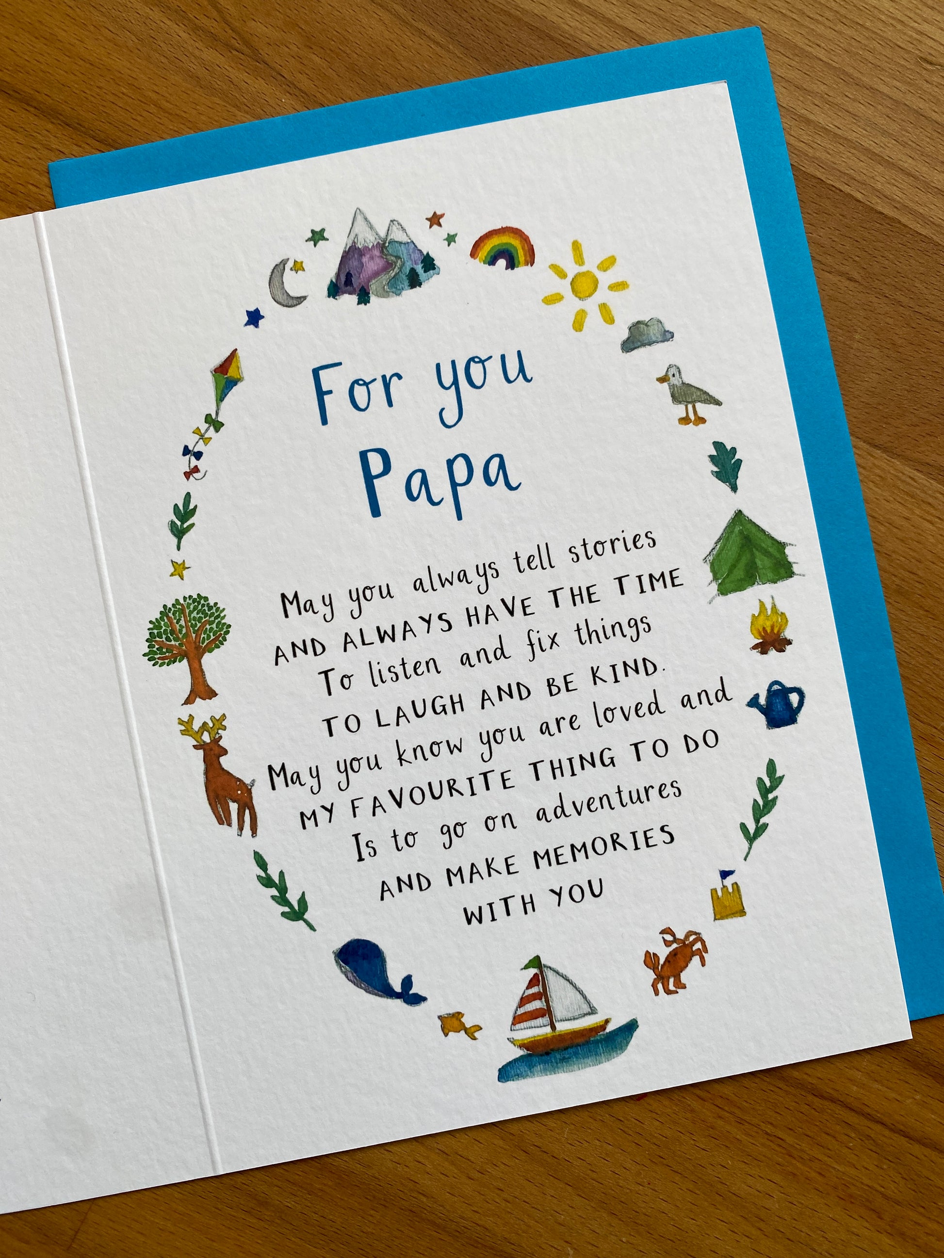 Greeting card for Papa with illustrations and text on a wooden surface