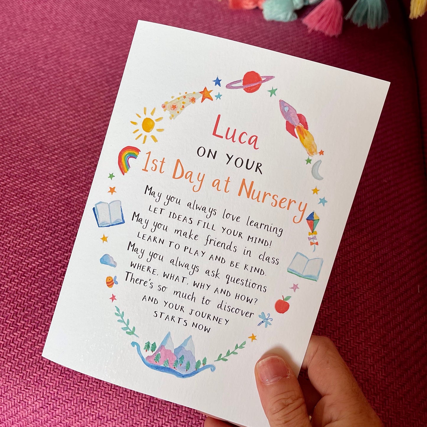 hand holding a greetings card featuring watercolour illustrations around a poem and personalised text 'luca on your 1st day at nursery'