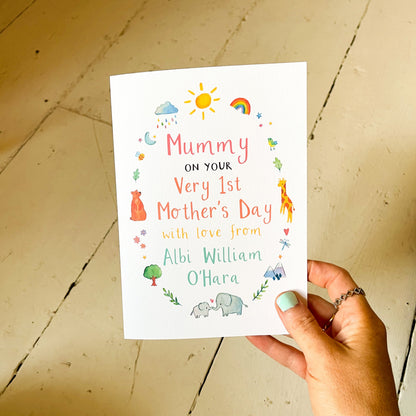 hand holding a greetings card featuring watercolour illustrations and the text 'mummy on your very first mother's day' and the personalised name of the child