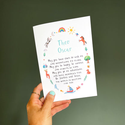 hand holding a white greetings card featuring colourful, watercolour illustrations surrounding a poem and the personalised name 'theo oscar'