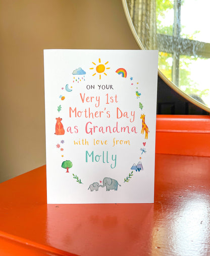 A personalized Mother's Day card for grandma with a watercolor illustration of a sun, birds, and flowers, and space for a personalised name. The card is displayed on a red surface.