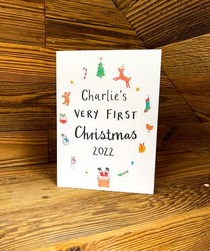 white greetings card with christmas watercolour illustrations and the text 'charlies very first christmas'
