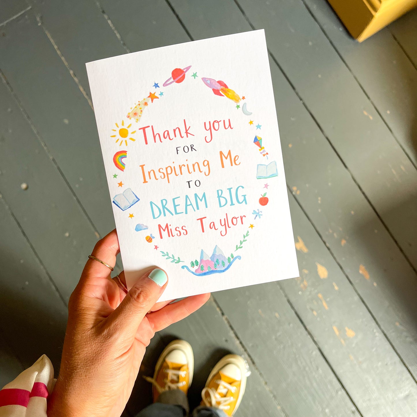 hand holding a white greetings card with the text 'thank you for inspiring me to dream big [personalised name]'
